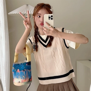 Mirror selfie showing collegiate v-neck knit vest with stripes and embroidered badge