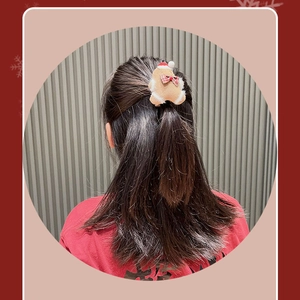 Plush Gingerbread Man hair clip with red Christmas hat shown on model hairstyle