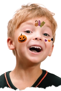 Boy wearing Halloween face tattoo stickers with cute pumpkin and candy patterns