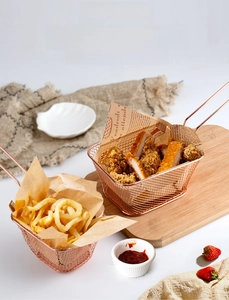 Panier à friture en acier inoxydable or rose avec frites dorées et poulet frit croustillant