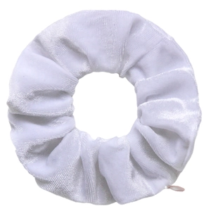 Detailed close-up of white velvet scrunchie showing soft texture and folded fabric