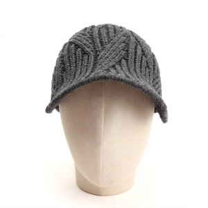 Detail of dark grey cable knit peaked cap with thick texture and warm wool lining