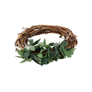 Detail of woven rattan napkin ring with realistic green leaves on a white background