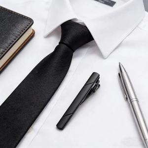 Close-up of matte black stainless steel tie clip with twill line on white shirt
