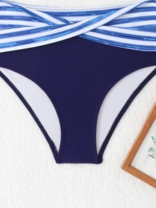Dettaglio slip bikini a vita alta blu navy con fascia incrociata a righe bianche