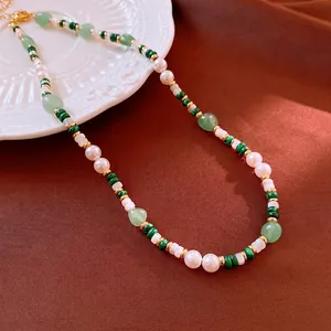 Elegant beaded pearl necklace with green malachite and gold metal accents on brown silk