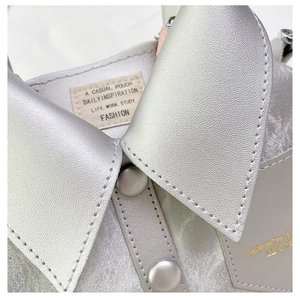 Macro shot of silver PU leather bag featuring unique shirt collar design and button details