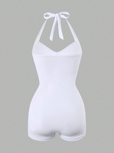 Back view detail of white halter one-piece swimsuit featuring open back and flat bottom