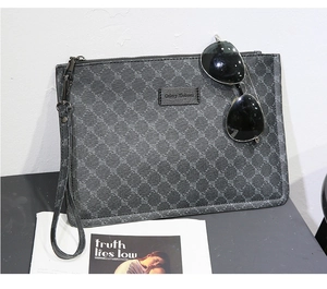 Detailed view of the dark grey patterned men's clutch bag with wrist strap and zipper.