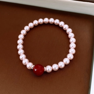 Détail macro du bracelet de perles avec une perle d'agate rouge et séparateurs argent