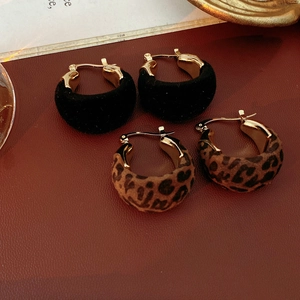 Dettaglio di orecchini vintage a cerchio con stampa leopardata e floccati neri