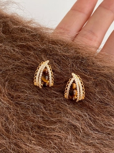 Detailed view of teardrop earrings with tiger eye stones and zircon inlay in gold