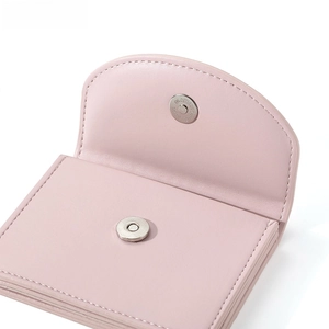 Detail of pink leather wallet featuring magnetic closure and multi-slot accordion interior