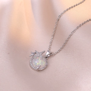 Macro shot of a dreamy planet opal pendant with silver stars on champagne silk fabric