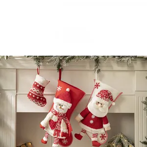 Three festive Christmas stockings featuring Santa and snowman hanging on a fireplace