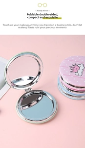 Detail of portable round folding makeup mirror in pink and green with leather texture