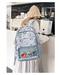 Close-up of cute dachshund backpack with clear pocket showing anime badges and charms