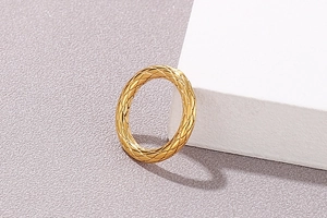 Makroaufnahme eines goldenen Edelstahlrings mit strukturiertem Rautenmuster im Relief