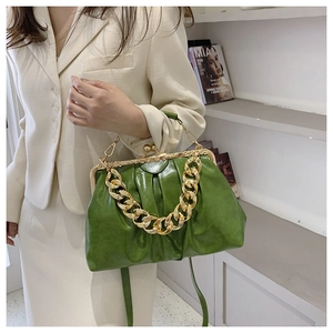 Detail of green oily leather handbag with gold chain strap and vintage clasp closure