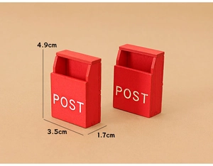 Detail view of two miniature red dollhouse mailboxes with 4.9cm height measurements