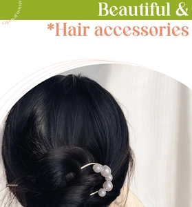 Gros plan sur l'épingle à cheveux en U élégante avec cinq perles blanches en chignon