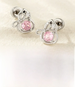 Macro detail of silver bow gourd stud earrings with pink zircon and 0.8mm surgical steel post
