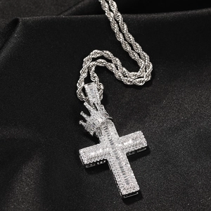 Macro shot of silver iced-out crown cross pendant with twisted rope chain on silk