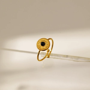 Adjustable gold ring with black round gemstone and sunburst relief on frosted glass