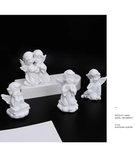 Detailed view of four white resin angel ornaments in prayer and reading poses