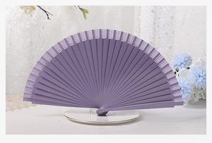 Close-up of light purple solid wood folding fan on white base with lace background