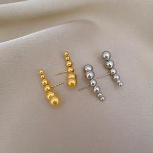 Detail of minimalist titanium steel stud earrings with five curved metallic beads