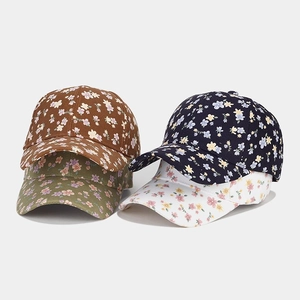 Detail view of floral baseball caps in brown, green, navy, and white floral patterns