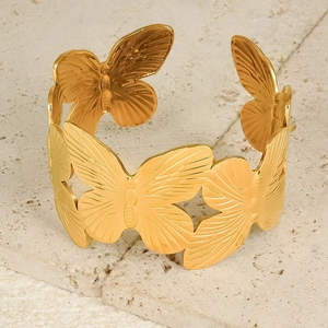Vista macro del bracciale rigido a farfalla placcato oro 18K con dettagli incisi