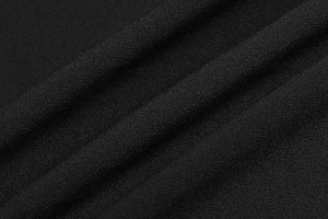 Dettaglio macro del tessuto a maglia nera con trama fine e morbido drappeggio