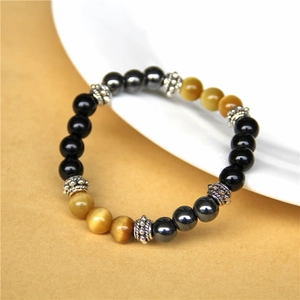 Detailed view of obsidian and tiger eye stone bead bracelet with silver alloy spacers