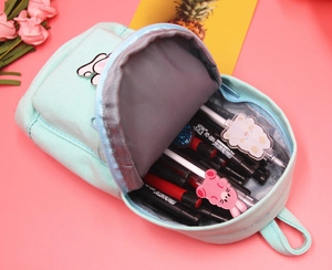 Close-up of mint green canvas pencil case featuring cute bunny badge and metal zipper