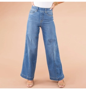 Close-up of high-waist loose wide-leg jeans in washed blue denim with front pleat detail