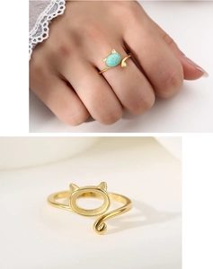 Detail of S925 sterling silver cat ear ring with green turquoise stone in golden finish