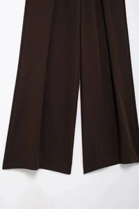 Vue détaillée du pantalon large marron foncé en tissu sergé avec drapé élégant