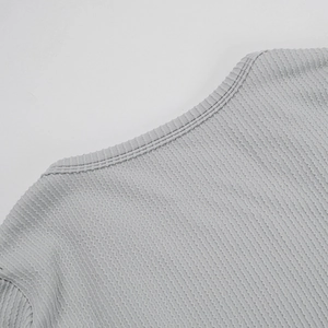 Detailed view of grey knitted bodysuit crew neck with premium rib texture and stitching