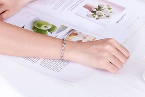 Close-up of a stylish stainless steel link chain bracelet worn on a woman's wrist