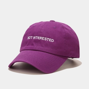 Close-up of purple cotton baseball cap with white Not Interested text embroidery