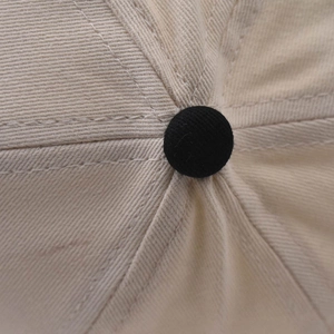 Macro detail of high-density twill fabric and reinforced top button on baseball cap