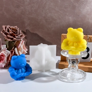 Macro view of silicone mold with finished muscle bear candles on a leather surface
