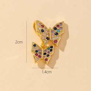 Macro detail of gold butterfly pendant showing dimensions of 2cm height and zircon inlay