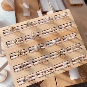 Detailed view of walnut wood display tray featuring 20 slots for gold and silver rings