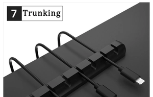 Close-up of a black silicone 4-slot cable organizer managing USB cords on a desk
