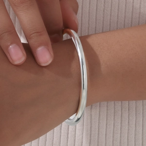 Detailed view of silver minimalist stainless steel polished cuff bracelet on wrist