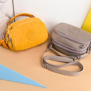 Minimalist nylon crossbody bags in yellow and grey with multi-layer zipper compartments