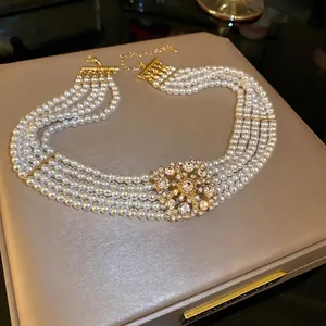 Multi-layer pearl necklace featuring a sparkling diamond floral pendant on velvet